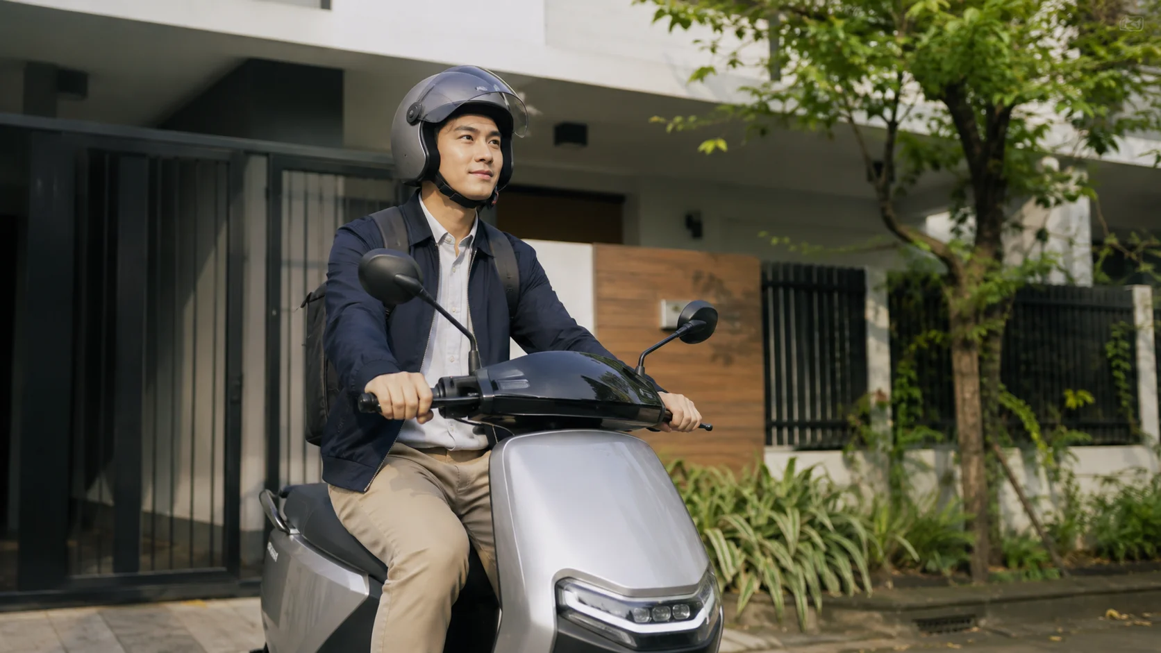 Pekerja Indonesia sedang berangkat ke kantor menggunakan motor listrik