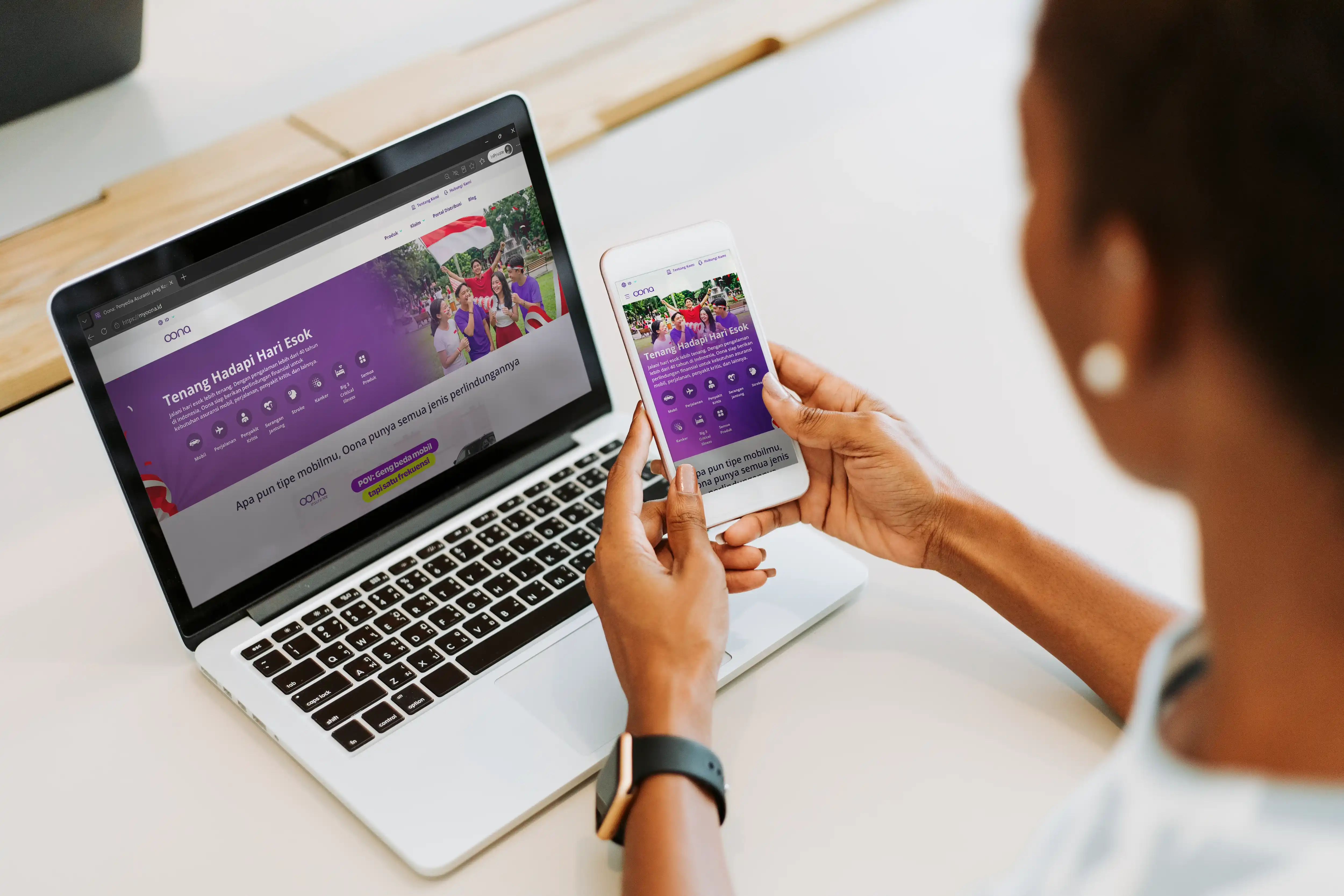 Person using a laptop and smartphone to access the Oona Insurance website
